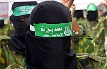 Masked Hamas militants in Gaza carry mock coffins of Palestinians who were killed during Israeli military operations.