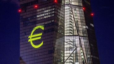 A light installation depicting the euro on the European Central Bank