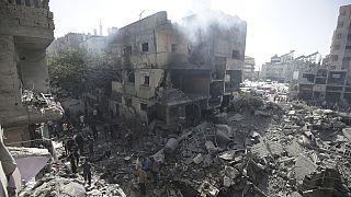 FILE - Palestinians look at the aftermath of the Israeli bombing in Nuseirat refugee camp, Gaza Strip, on June 8, 2024.