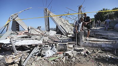رجال لبنانيون يتفقدون منزلا مدمرا ضربته غارة جوية إسرائيلية ليلة الجمعة.