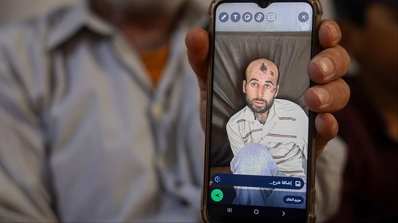 وليد محمد عبد الباقي يظهر صورة ابنه القتيل علي على هاتفه المحمول في إدلب، سوريا، الاثنين 27 مايو 2024.