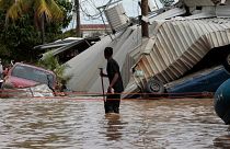 Auf diesem Dateifoto vom 6. November 2020 blickt ein Anwohner, der durch eine überflutete Straße geht, auf die Sturmschäden des Hurrikans Eta in Planeta, Honduras, zurück.