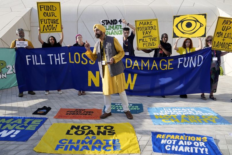 Activistas participan en una manifestación por pérdidas y daños en la COP28.