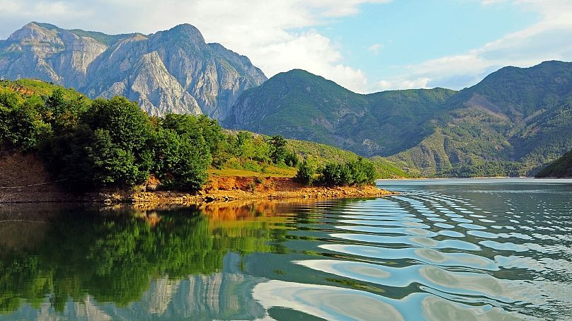 Relájese en el lago Komani, Albania.