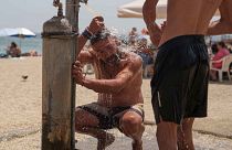 Giannis Mpekos takes a shower at a beach in Faliro seaside district of Athens, on Thursday June 13, 2024.