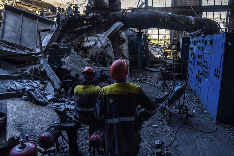 Des ouvriers se tiennent parmi les débris d'une centrale thermique DTEK endommagée après une attaque russe en Ukraine, jeudi 2 mai 2024.