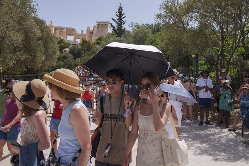 Touristen verlassen die antike Akropolis im Zentrum Athens, Mittwoch, 12. Juni 2024. Die antike Stätte war aufgrund starker Hitze zwischen 12 und 17 Uhr geschlossen.