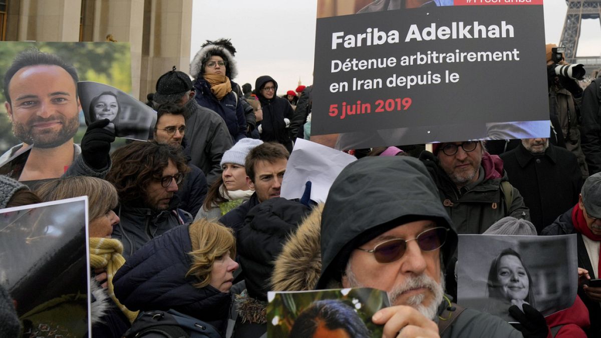 Pessoas seguram retratos de franceses detidos no Irão, incluindo Louis Arnaud, durante um protesto em Paris, sábado, 28 de janeiro de 2023.