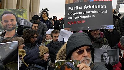 Pessoas seguram retratos de franceses detidos no Irão, incluindo Louis Arnaud, durante um protesto em Paris, sábado, 28 de janeiro de 2023.