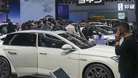 Visitors look at cars at the BYD booth during the China Auto Show in Beijing, China, Friday, April 26, 2024. 