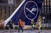 Streikende Flugbegleiter der Lufthansa gehen an einem Flugzeugheck in Frankfurt am Main vorbei, Dienstag, 12. März 2024. 