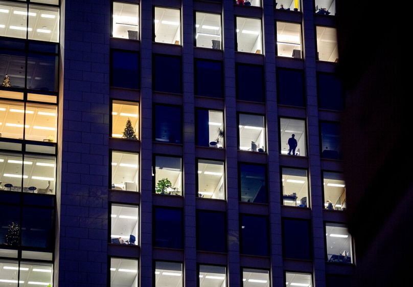 Un hombre mira por la ventana de un edificio de oficinas en Frankfurt, diciembre de 2022.