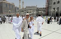 Two blind pilgrims preform Hajj with the help of their guide outside of the Grand Mosque during the annual pilgrimage in Mecca, Saudi Arabia, Thursday, June 13, 2024.