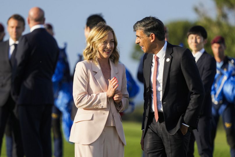 Italian Prime Minister Giorgia Meloni, left, talks to Britain's Prime Minister Rishi Sunak after watching a skydiving demo during the G7 world leaders summit at Borgo Egnazia.
