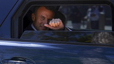 French President Emmanuel Macron thumbs up from his car after voting for the European election, Sunday, June 9, 2024