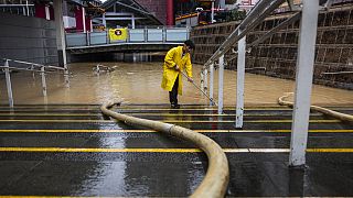 عامل يزيل المياه في شارع غمرته المياه بعد عواصف مطيرة غزيرة في هونغ كونغ