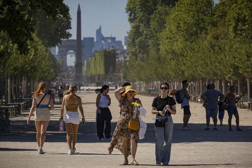 Des personnes se promenant à l'ombre dans le Jardin des Tuileries, à Paris, en  11 août 2022.