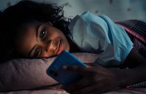 A woman in bed with her phone.