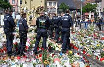 پلیس مانهایم و دسته‌های گل روی زمین در محل حمله با چاقو به افسر پلیس 