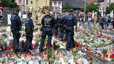 پلیس مانهایم و دسته‌های گل روی زمین در محل حمله با چاقو به افسر پلیس 