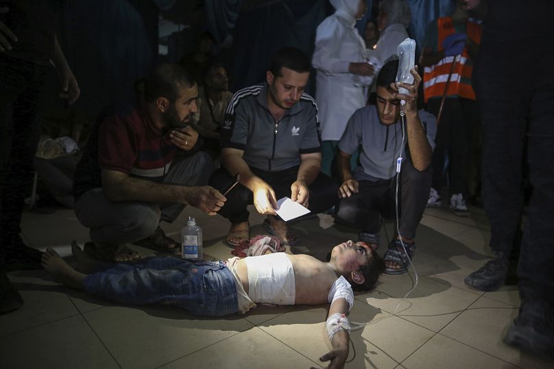 İsrail saldırılarında yaralanan Filistinli bir kıza müdahalede bulunuluyor.