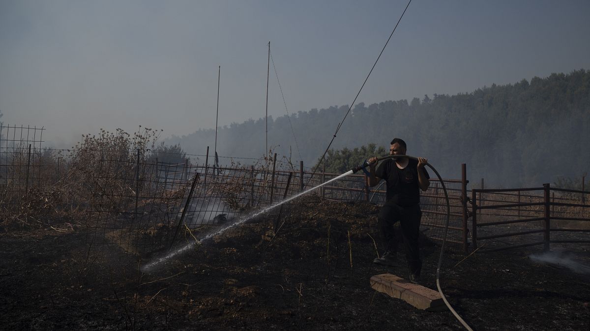 رجل إطفاء إسرائيلي يعمل على إخماد حريق اشتعل بسبب صاروخ لحزب الله 