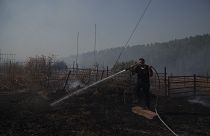 رجل إطفاء إسرائيلي يعمل على إخماد حريق اشتعل بسبب صاروخ لحزب الله 