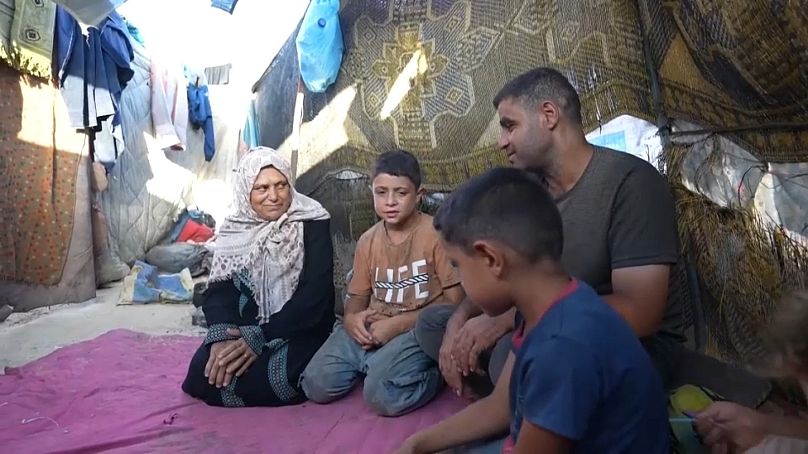 نادية حمودة وعائلتها في خيمة لجأوا إليها هربا من القصف في دير البلح في قطاع غزة 