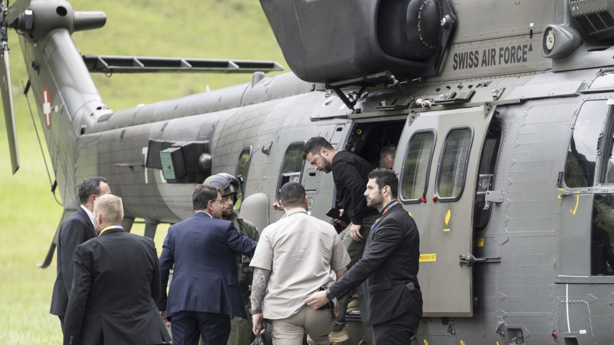 El Presidente de Ucrania, Volodymyr Zelenskyy, en el centro, baja de un helicóptero Super Puma de las Fuerzas Aéreas Suizas tras su aterrizaje en Obbuergen, cerca del complejo turístico de Burgenstock.