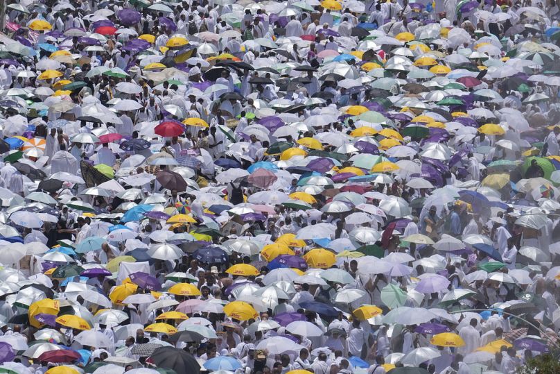 Des pèlerins musulmans utilisent des parapluies pour se protéger du soleil à l'extérieur de la mosquée Nimrah pour faire la prière de midi à Arafat