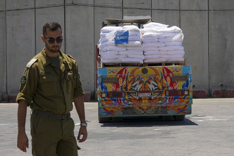 سرباز اسرائیلی در کرم شالوم در کنار کمک کمک‌های بشردوستانه به تاریخ ۳۰ مه ۲۰۲۴