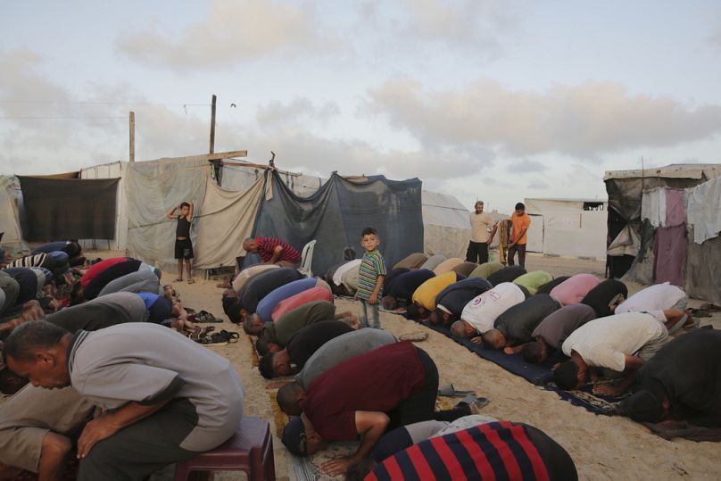 Palästinenser verrichten das Eid al-Adha-Gebet in einem Zeltlager in Chan Jounis, Gaza, Sonntag, 16. Juni 2024.