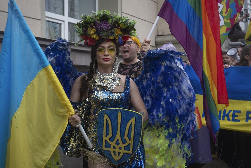 أشخاص يشاركون في موكب المثليين السنوي، تحت حماية شرطة مكافحة الشغب في كييف