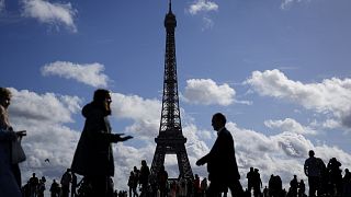People walk at the Trocadero square with the Eiffel Tower in the background in Paris, France