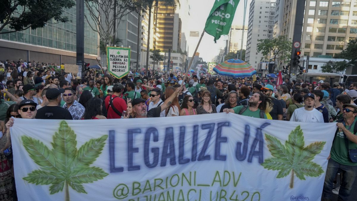 Demonstrators hold a banner that reads in Portuguese, "Legalize now," during a march demanding the legalization of marijuana in Sao Paulo, Sunday, June 16, 2024.