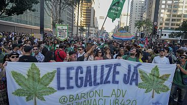 متظاهرون يحملون لافتة كتب عليها بالبرتغالية "إضفاء الشرعية الآن" خلال مسيرة تطالب بتشريع الماريجوانا في ساو باولو