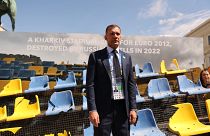 Ukraine Football Association chief Andriy Shevchenko stands in front of the rests of a bombarded Ukrainian football stadium