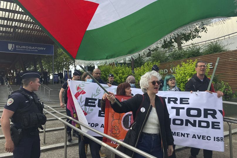 Des manifestants se rassemblent devant l'exposition Eurosatory, un événement mondial pour la défense et la sécurité, à Villepinte, près de Paris, le lundi 17 juin 2024.
