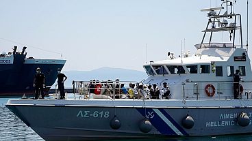 Göçmenler, Yunanistan'ın Midilli adasındaki Midilli limanına sahil güvenlik gemisiyle geliyor