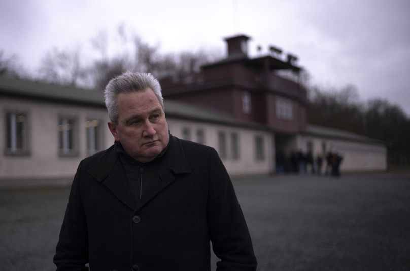 Jens-Christian Wagner pose près de la porte principale de l'ancien camp de concentration nazi de Buchenwald à Weimar. en janvier 2024. 