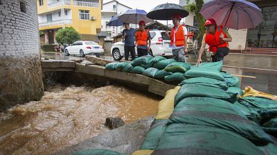 في الصورة الملتقطة يوم 16 يونيو 2024، عمال يتفقدون إجراءات الوقاية من الفيضانات في قناة تصريف في قرية هونغ شينغ ببلدة شينغتسون في وويشان بمقاطعة فوجيان جنوب شرق الصين.