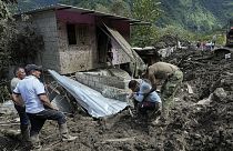 Residents traverse terrain anc count their losses after landslides in Banos, Ecuador, Monday, June 17, 2024