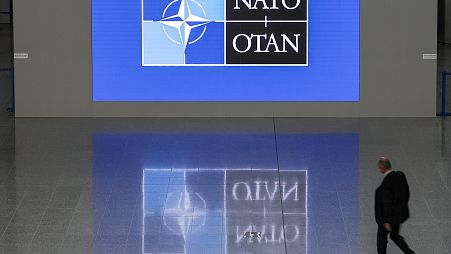 A man walks in the lobby of the NATO headquarters, Wednesday, Nov. 16, 2022 in Brussels. 