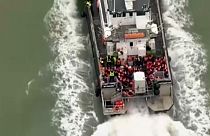 Imagen de un grupo de inmigrantes que son rescatados por una embarcación de la Fuerza de Fronteras del Reino Unido en el canal de la Mancha.