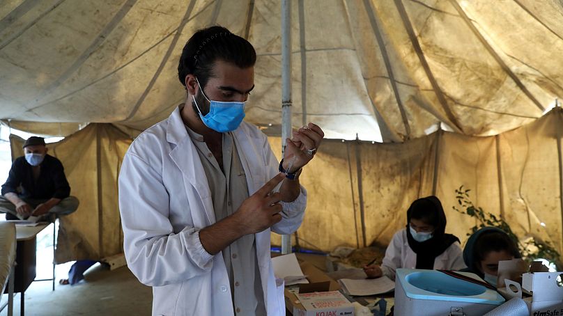 Un medico riempie una siringa con una dose di vaccino anti-Covid in un centro di vaccinazione a Kabul, Afghanistan, 2021.