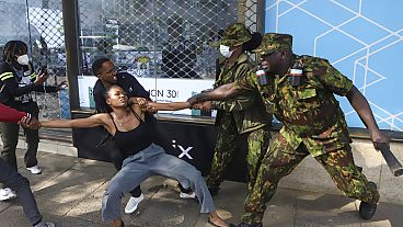 ضباط الشرطة يعتقلون متظاهرًا يحتج على الزيادات الضريبية المقترحة في مشروع قانون المالية المقرر تقديمه إلى البرلمان في نيروبي