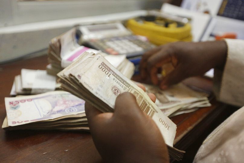 A money changer counts Nigerian naira currency at a bureau de change in Lagos, October 2015