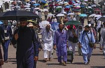Muslim pilgrims use umbrellas to shield themselves from the sun as they arrive to the last rite of the annual hajj, in Mina, 18 June 2024