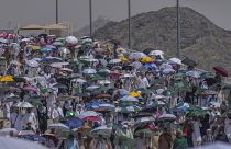 حجاج يحملون مظلات علها تخفف عنهم حرارة الشمس اللاهبة في مدينة مكة 