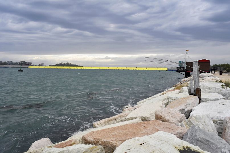 Se levantan barreras amarillas durante la marea alta en Venecia, norte de Italia, el sábado 3 de octubre de 2020.